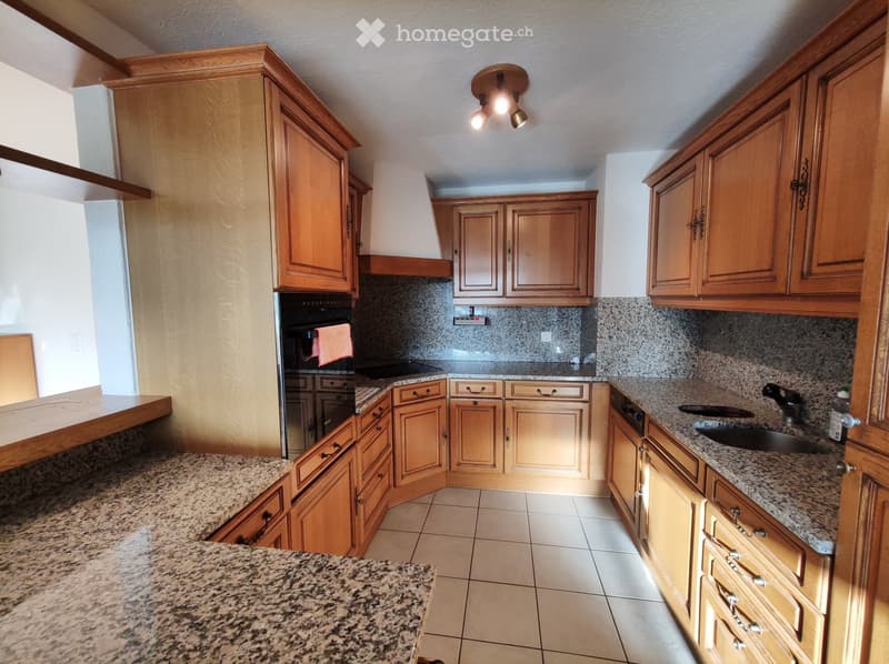 Spacious kitchen with wooden cabinetry, granite countertops, tile flooring, and a dishwasher