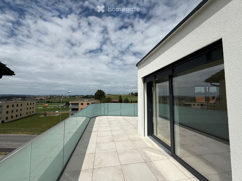 Balcony with glass railing, tiled floor, panoramic view of the countryside