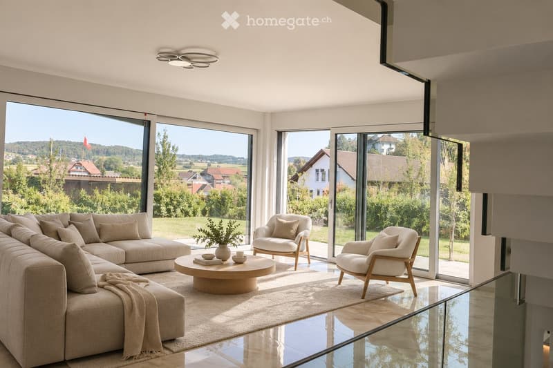 Modern living room with large windows offering a scenic view, featuring a beige sectional sofa, a round coffee table, two armchairs, a vase with greenery, and a cup on the table.