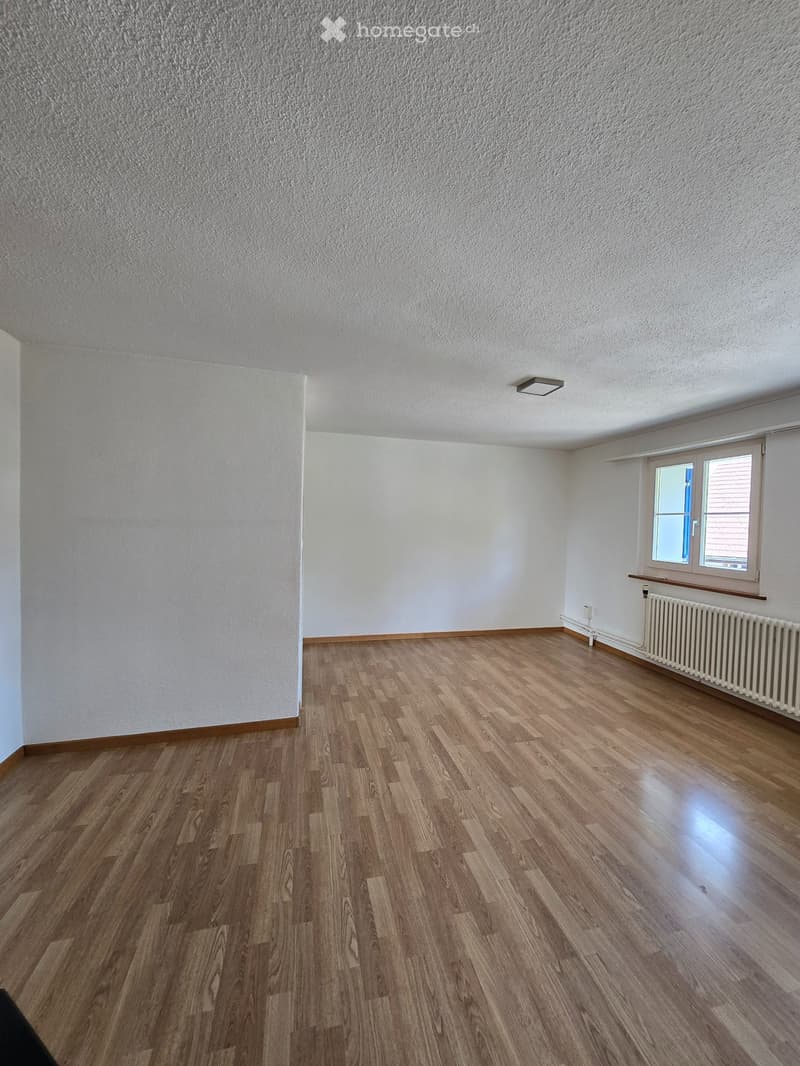 Empty room with wooden flooring, white walls, and a window with blinds. No furniture or equipment is present.
