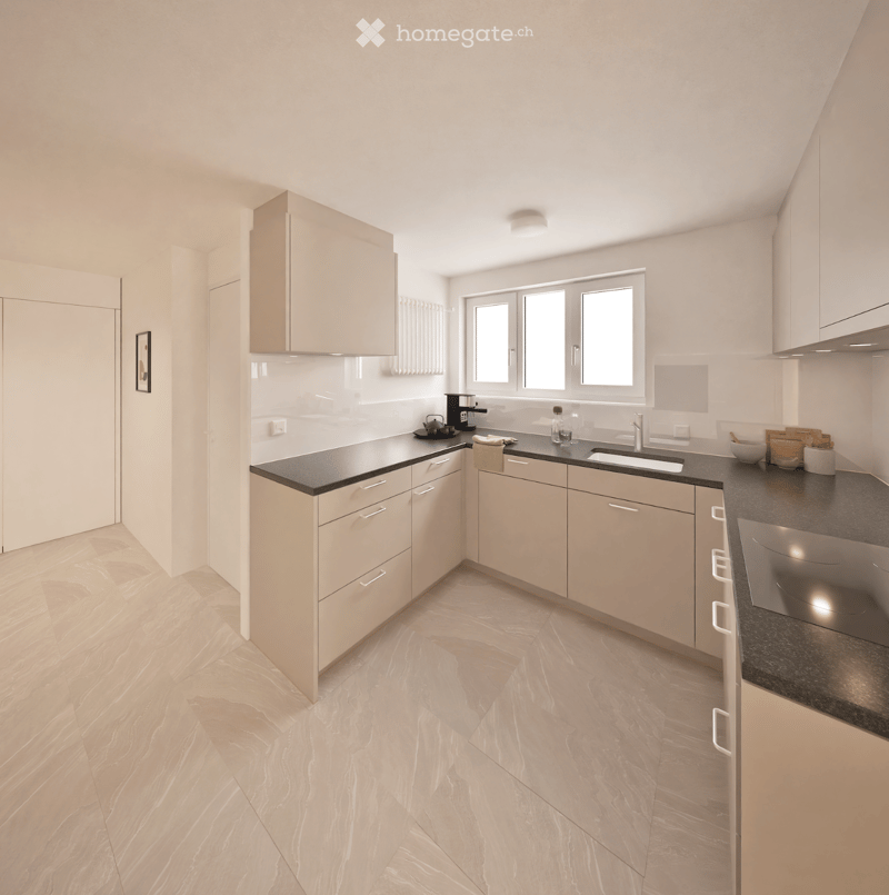 Modern kitchen with light-colored cabinets, black countertops, and a window above the sink. Includes a coffee maker, teapot, and other small appliances on the counter.