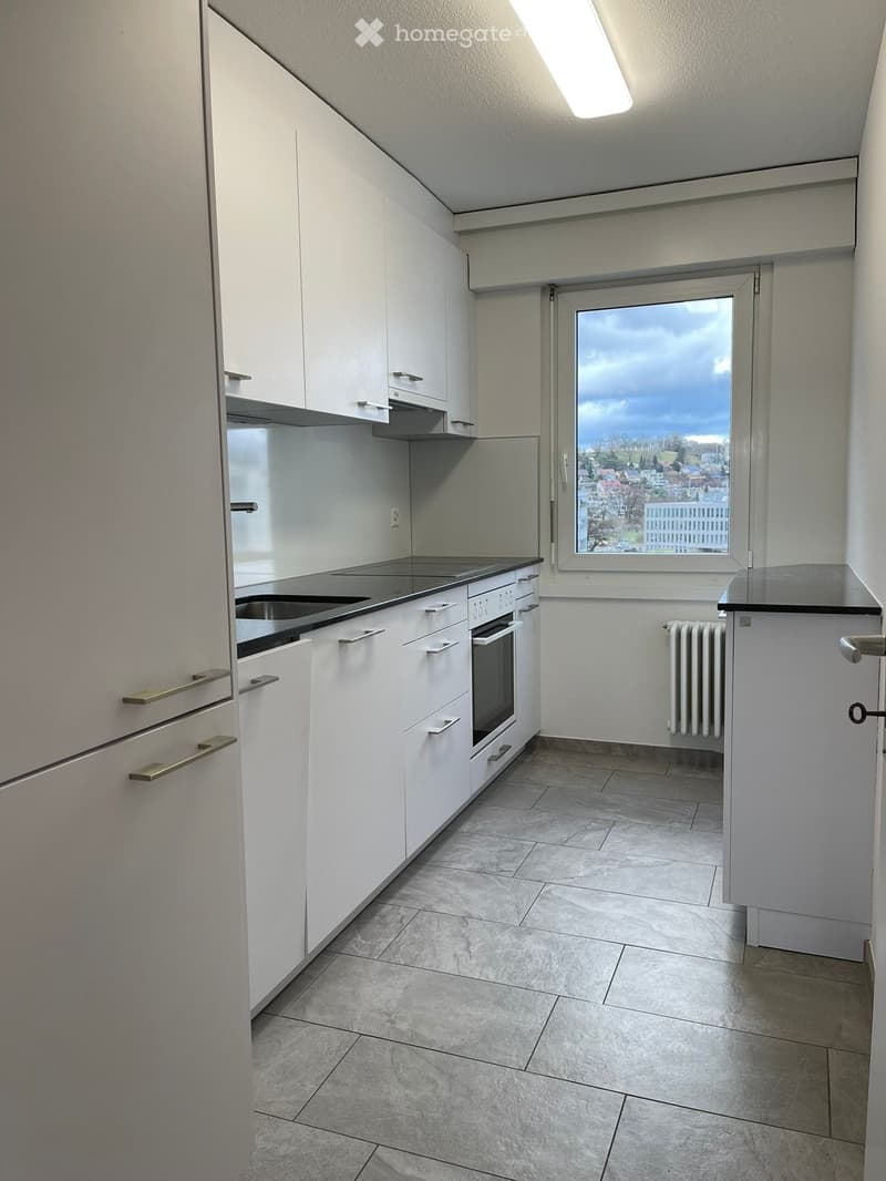 modern kitchen, white cabinets, granite countertops, large window with a city view, tiled floor, built-in appliances, white refrigerator