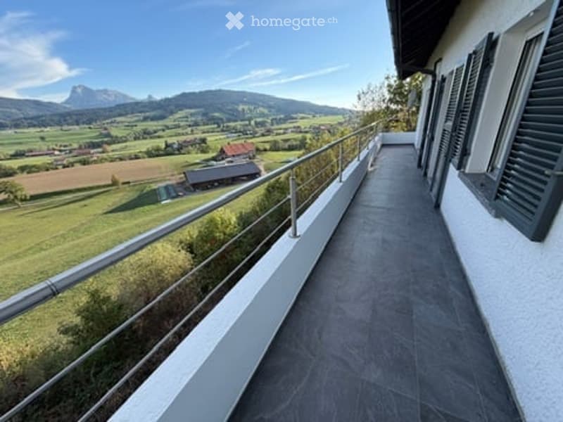 Balcony with a scenic mountain view, modern metal railing, tiled flooring, and white walls.
