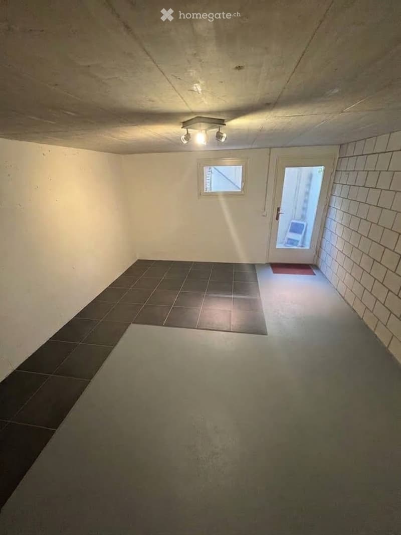 Empty room with tiled floor, white walls, and a small window. No furniture or equipment present.