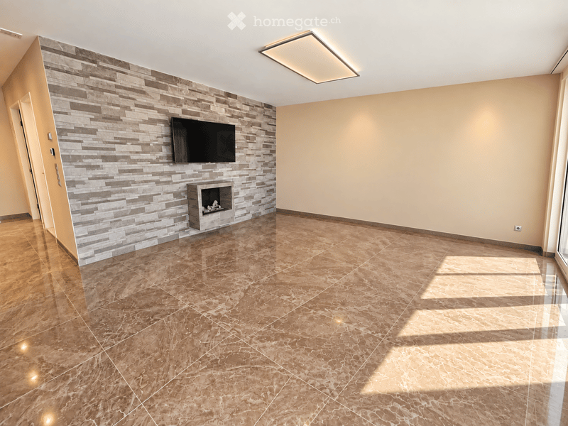 Modern living room with polished tile flooring, a built-in fireplace, and a mounted television on a textured wall.