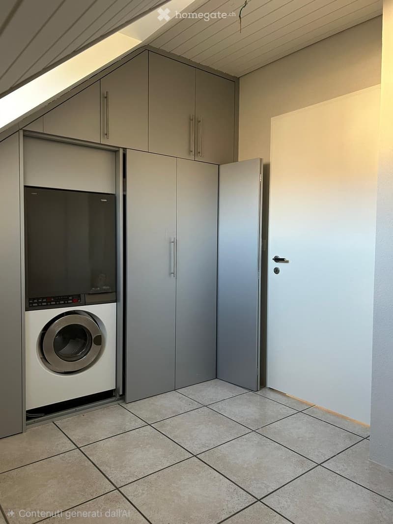Modern bathroom with tiled floor, grey cabinets, and a built-in washing machine.