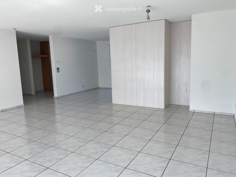 Empty room with white walls, tiled floor, and a small closet visible in the background.