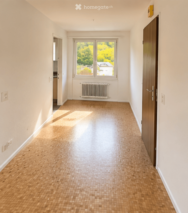 Empty room with light wooden flooring, white walls, and a large window with a view of greenery. No furniture or equipment present.