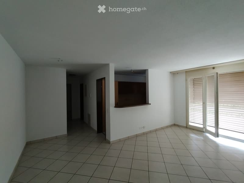 Empty room with tiled floor, white walls, and large windows with blinds. No furniture or equipment present.