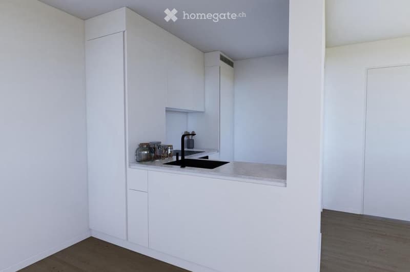 Modern, minimalist kitchen with white cabinets, a black sink, and a light-colored countertop. Several jars are placed on the counter.