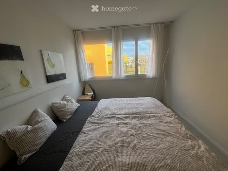 room, bed, pillows, nightstand, mirror, large window, paintings, yellow building view