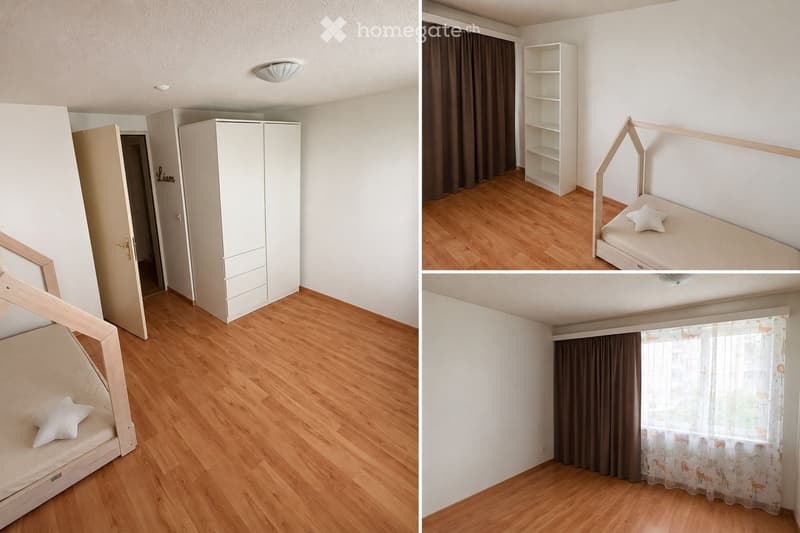 A small, modern bedroom with a wooden bed, a white wardrobe, a shelf, and curtains on the windows.