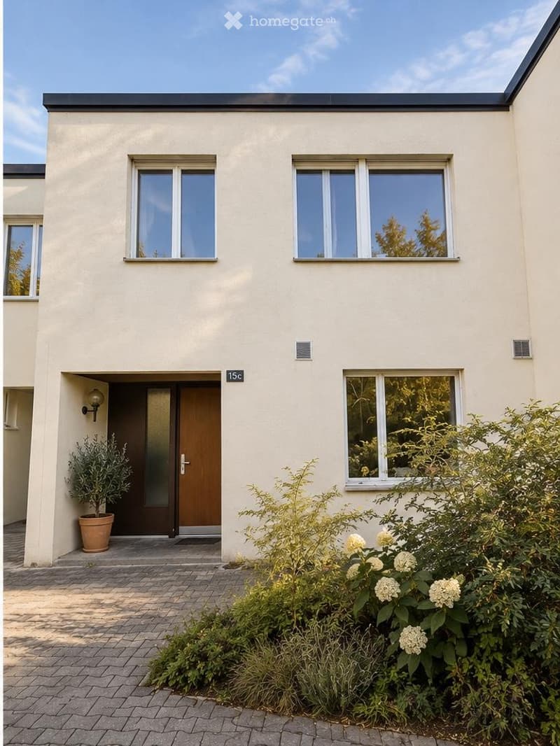 Modern two-story house with white facade, large windows, and a small garden area with shrubs and a potted plant near the entrance.