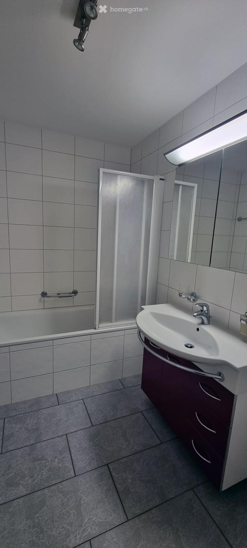 white tiles, bathtub, shower, vanity with sink and cabinet, mirror, ceiling lamp