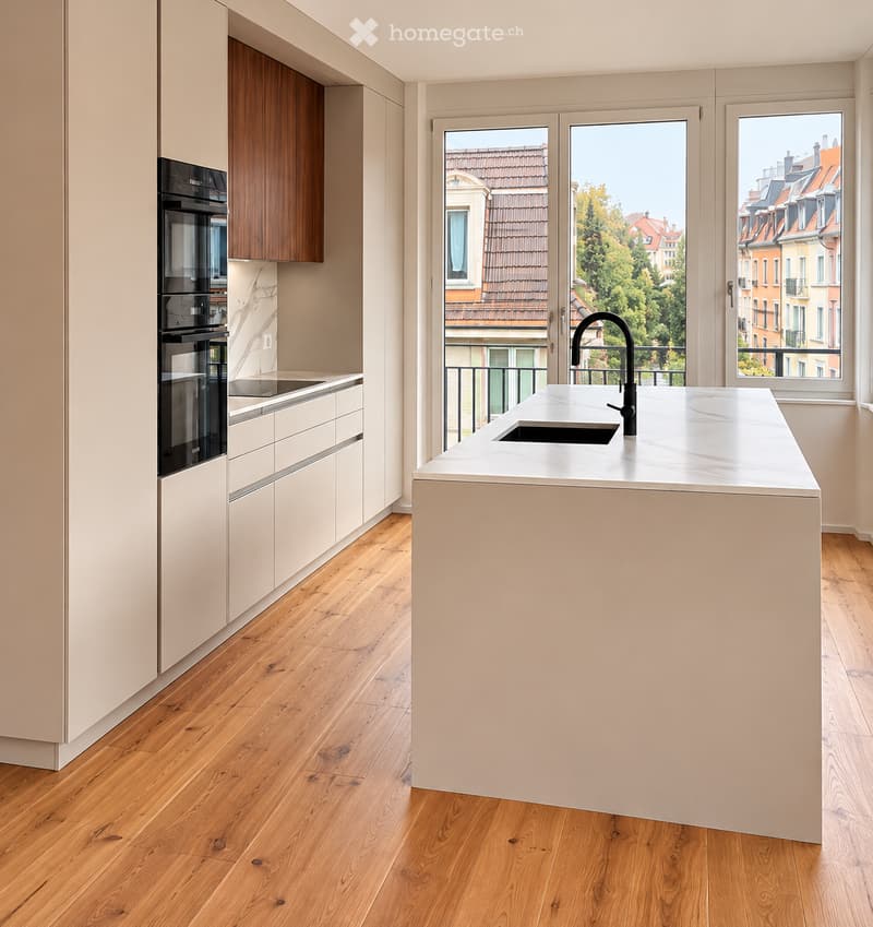 Modern kitchen with light-colored cabinets, a central island, and a sleek sink with a modern faucet. The space features wooden flooring and large windows offering a view of the city.