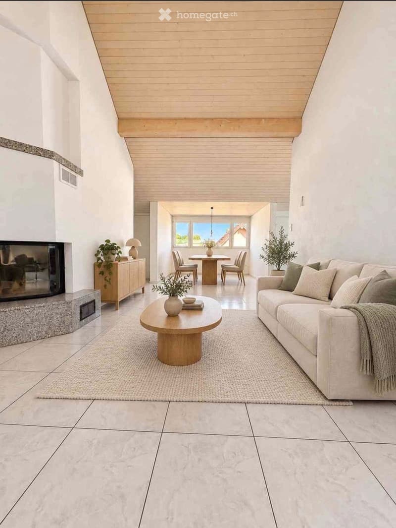 Modern living room with a large white sofa, coffee table, fireplace, side table, dining area with chairs and table, and potted plants.
