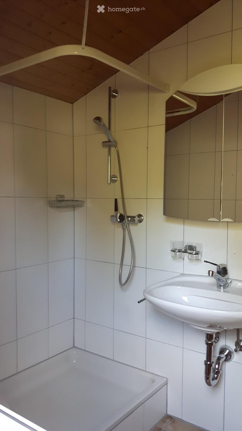 Bathroom with white tiles, bathtub, shower, sink, mirror, and faucet