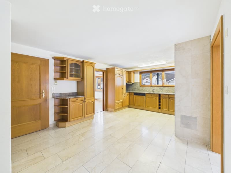 Bright, spacious kitchen with light wooden cabinets, granite countertops, and a tiled floor. Features a sink, dishwasher, and ample storage space.