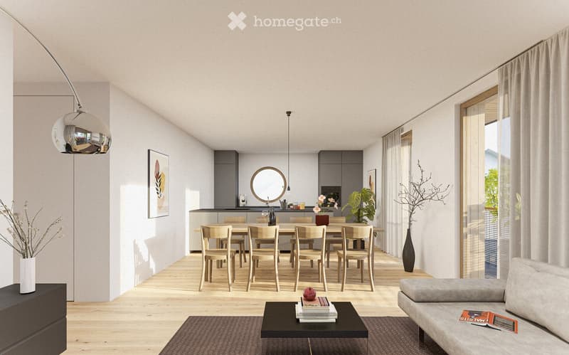Open-plan living and dining area with light wood flooring, modern furniture, and large windows with sheer curtains. Features a grey sofa, coffee table with books, dining table with chairs, pendant lights, and a kitchen area with cabinets and a sink.