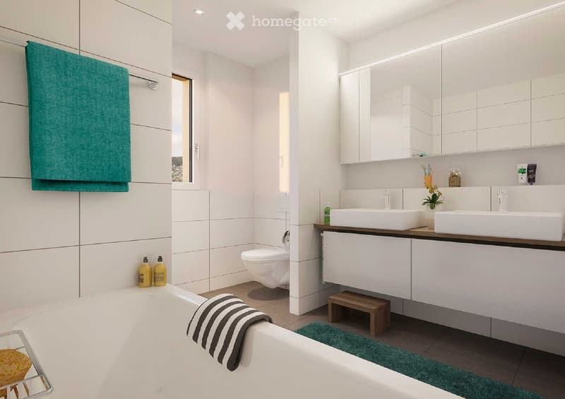 Modern bathroom with white tiles, a bathtub, toilet, double sink, mirrored cabinet, and a small wooden stool. Green towels and a striped towel are placed on the edge of the bathtub and near the sink.