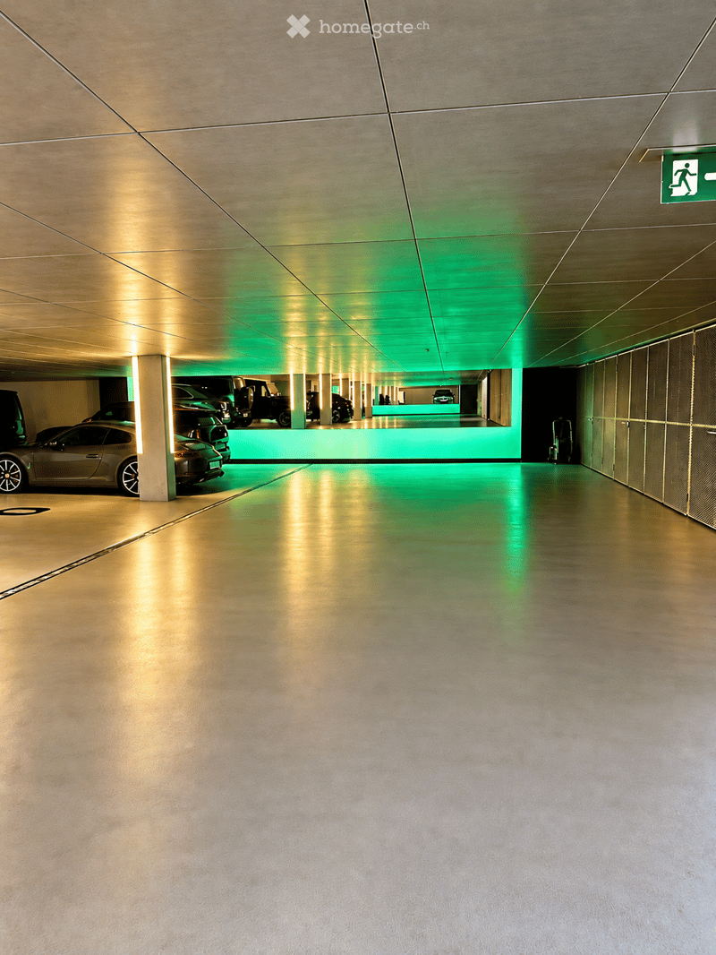 {"type": "Parking place", "objects": [], "description": "Modern underground parking area with sleek, metallic finishes, illuminated by green and yellow lighting, featuring several parked cars and a clean, spacious layout.", "localized_descriptions": {"EN"