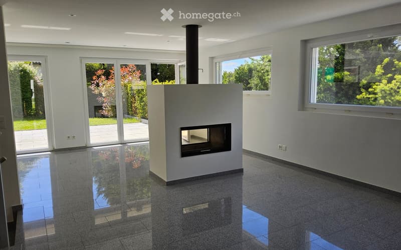 Modern living room with large windows, fireplace, and polished tile flooring.