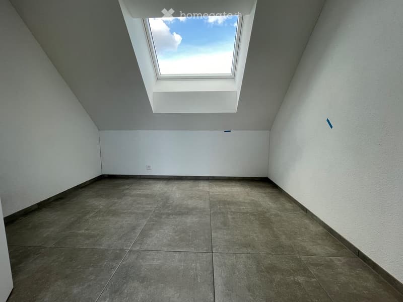 Empty room with white walls, concrete floor, and a skylight window at the top.