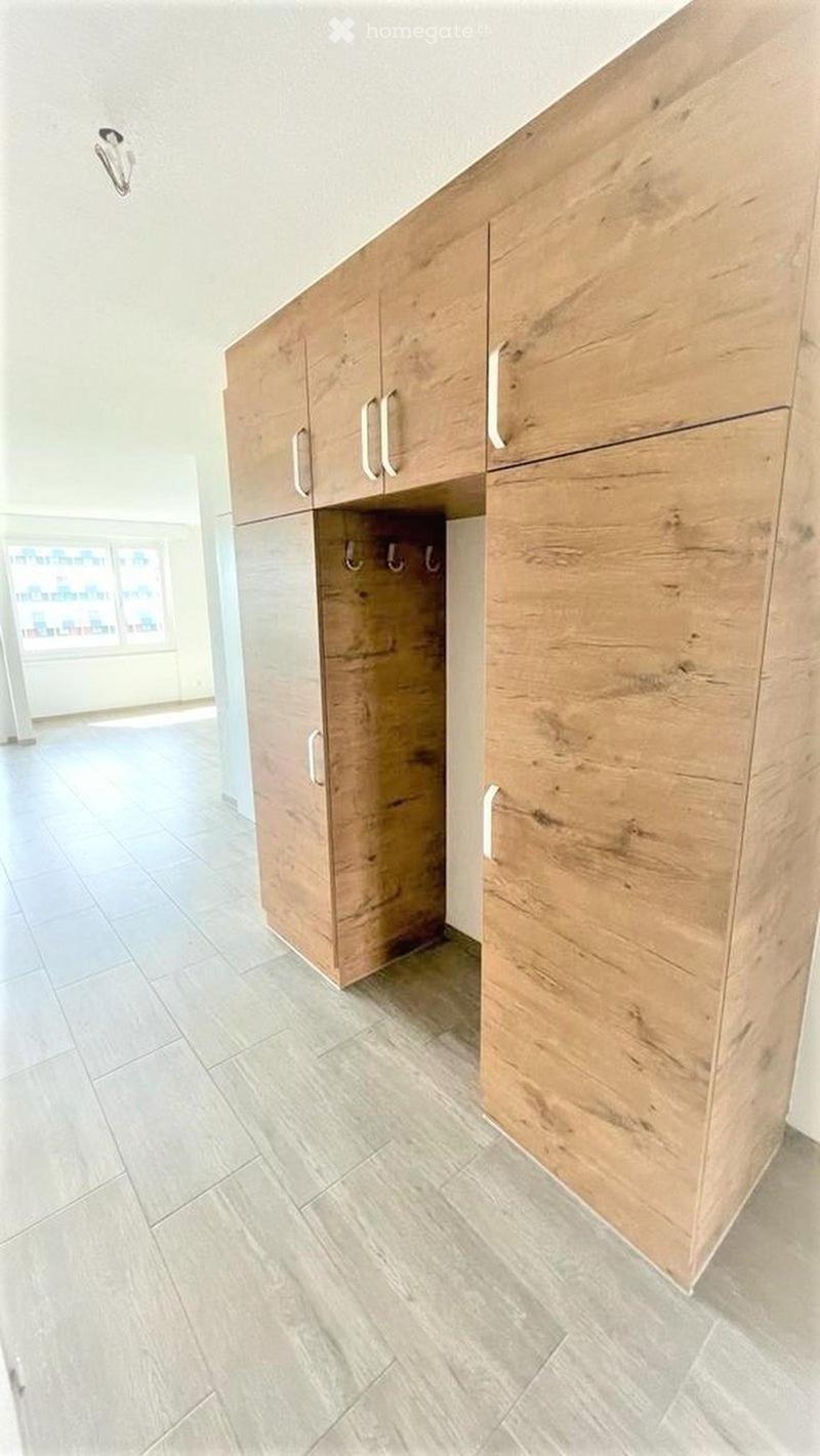 Empty room with light wooden cabinets and tiled floor, no furniture or equipment present.