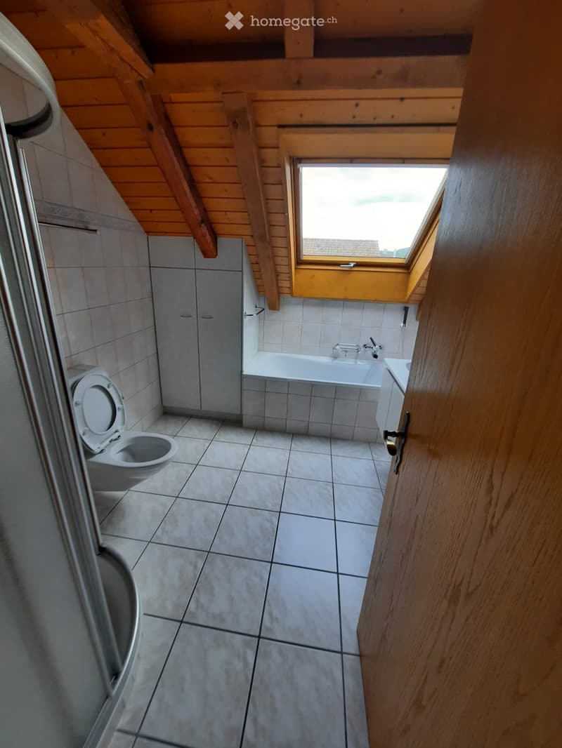 Bathroom with wooden ceiling, tiled floor, toilet, bathtub, sink, and cabinet.