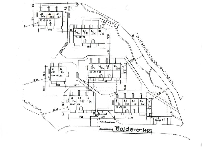Floor plan of a multi-unit building with labeled rooms and dimensions, including apartments, garages, and surrounding property boundaries.