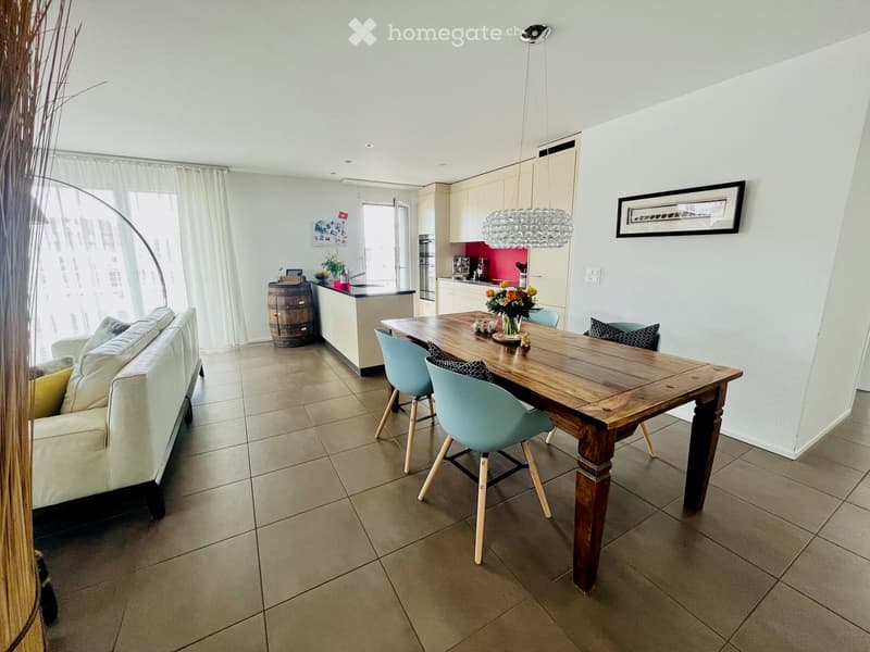 open floor plan with kitchen, dining area, and living area with couch, tile flooring, and large windows