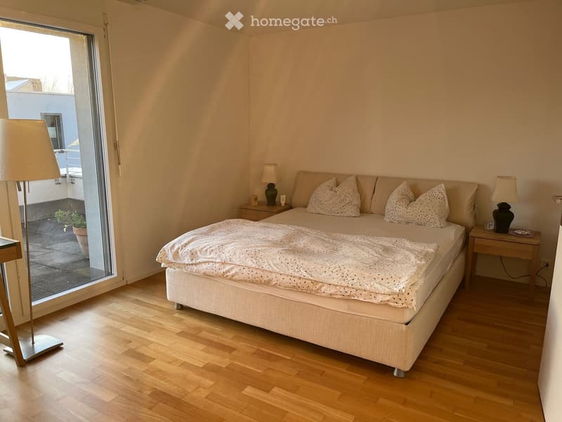 double bed with white bedding, wooden floor, lamps, nightstands, sliding glass door, balcony