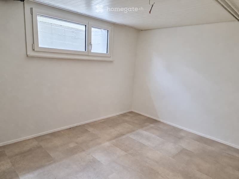 Empty room with light-colored tiled flooring and white walls, featuring a single window with frosted glass panels.