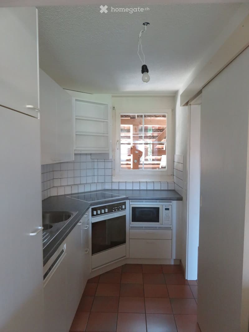 Modern kitchen with white cabinets, stainless steel appliances, and tiled backsplash. Features an oven, microwave, and sink.