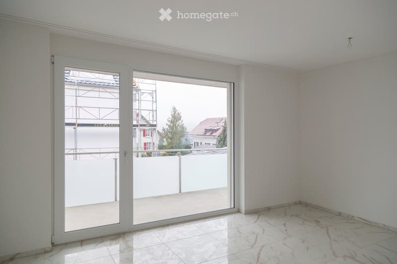 Empty room with white walls, marble flooring, and large sliding glass doors leading to a balcony.