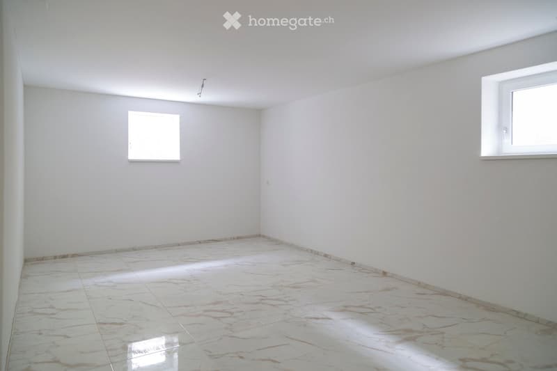 Empty room with white walls, marble tiled floor, and two windows allowing natural light.