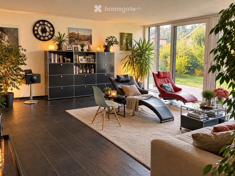 Modern living room with dark wooden flooring, large windows, and contemporary furniture including a sofa, chairs, a coffee table, and a bookshelf.
