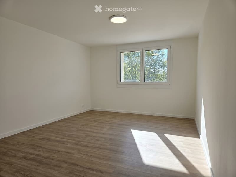 Empty room with wooden flooring, white walls, and a single window with white frame. No furniture or equipment present.