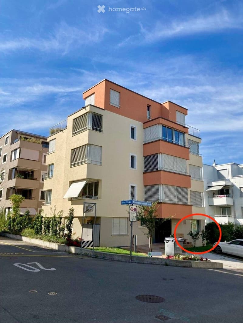Modern multi-story residential building with balconies, large windows, and a mix of beige and peach-colored facades.