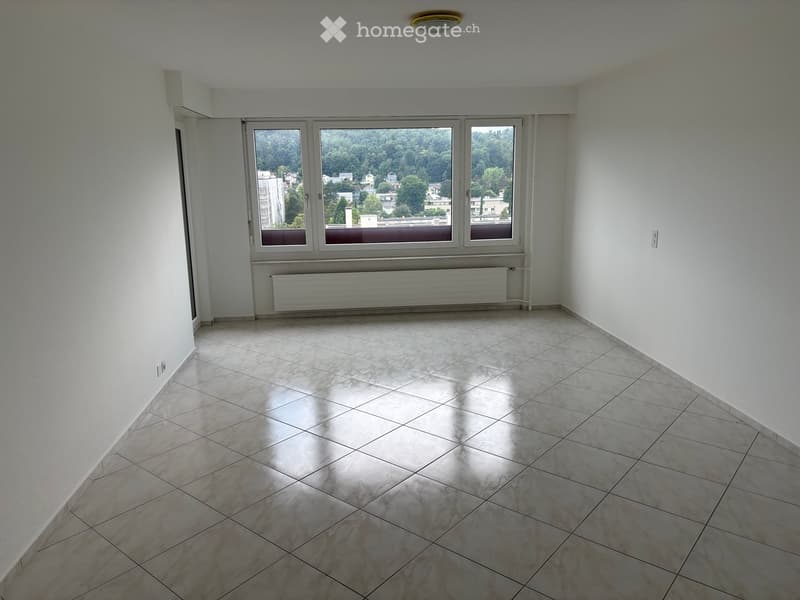Empty room with tiled floor, large windows, radiator, and white walls.