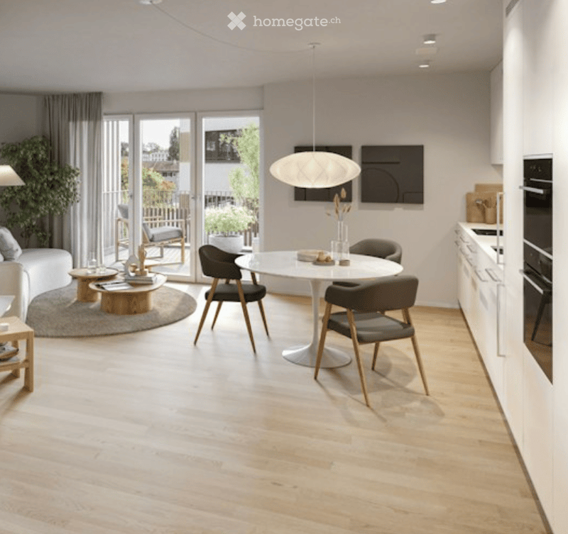Modern, open-plan living and dining area with light wood flooring, white dining table, grey chairs, sofa, pendant light, and kitchen area with cabinets and oven. Large windows and sliding doors lead to a balcony.