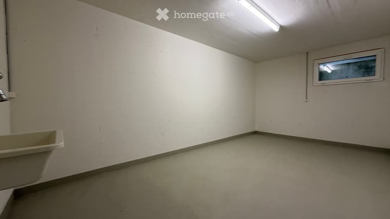 Empty room with white walls, a small window, and a bathtub in the corner.