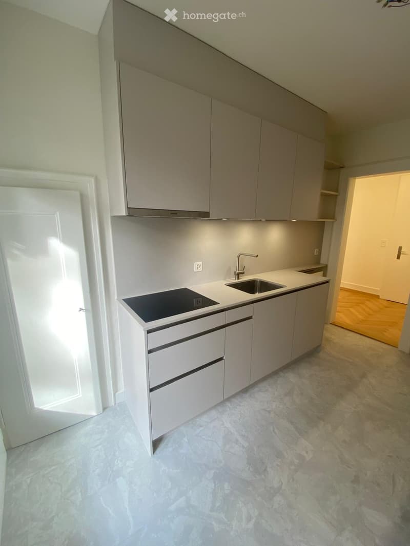 white cabinets, white marble countertop, induction hob, stainless steel sink, faucet, dishwasher, washing machine