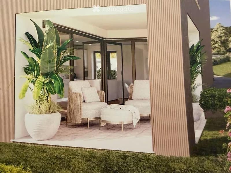 Modern balcony with white wicker chairs, ottoman, large potted plants, and a view of the garden.