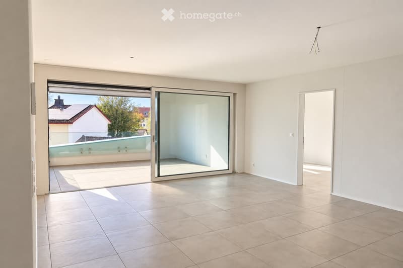 Empty room with tiled floor, large sliding glass doors leading to a balcony, white walls, and a visible outdoor pool area beyond the doors.