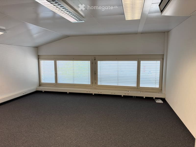 Empty room with white walls, carpeted floor, large windows with blinds, and recessed lighting.