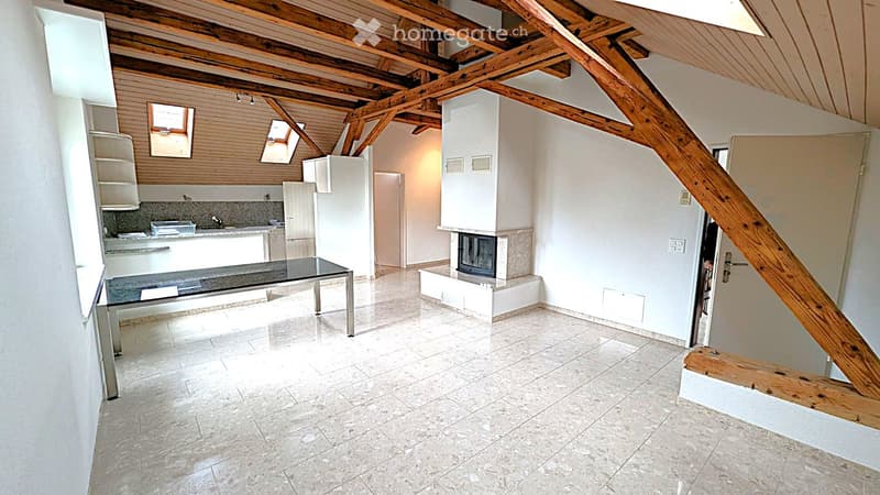 Open-plan living and dining area with exposed wooden beams, a modern kitchen, a fireplace, and a dining table.