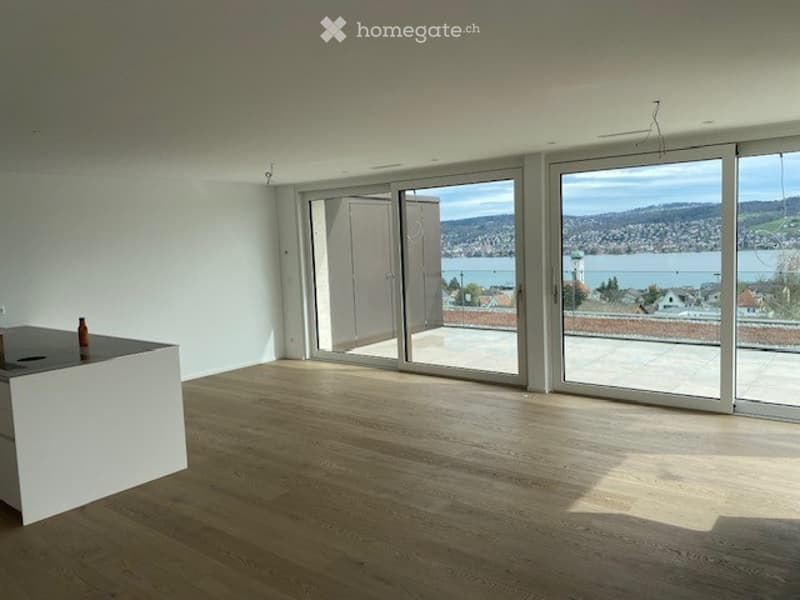 Open floor plan, large glass sliding doors, wooden floors, panoramic lake view