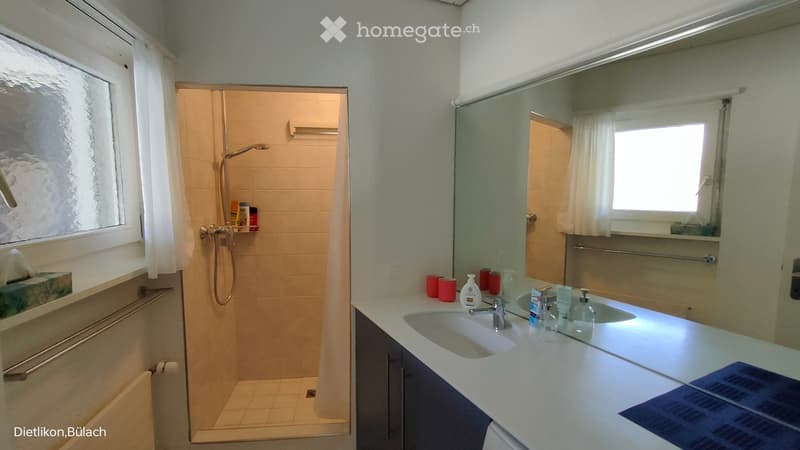 Bathroom. Bathroom with a double sink, mirror, shower, and various toiletries on the counter.