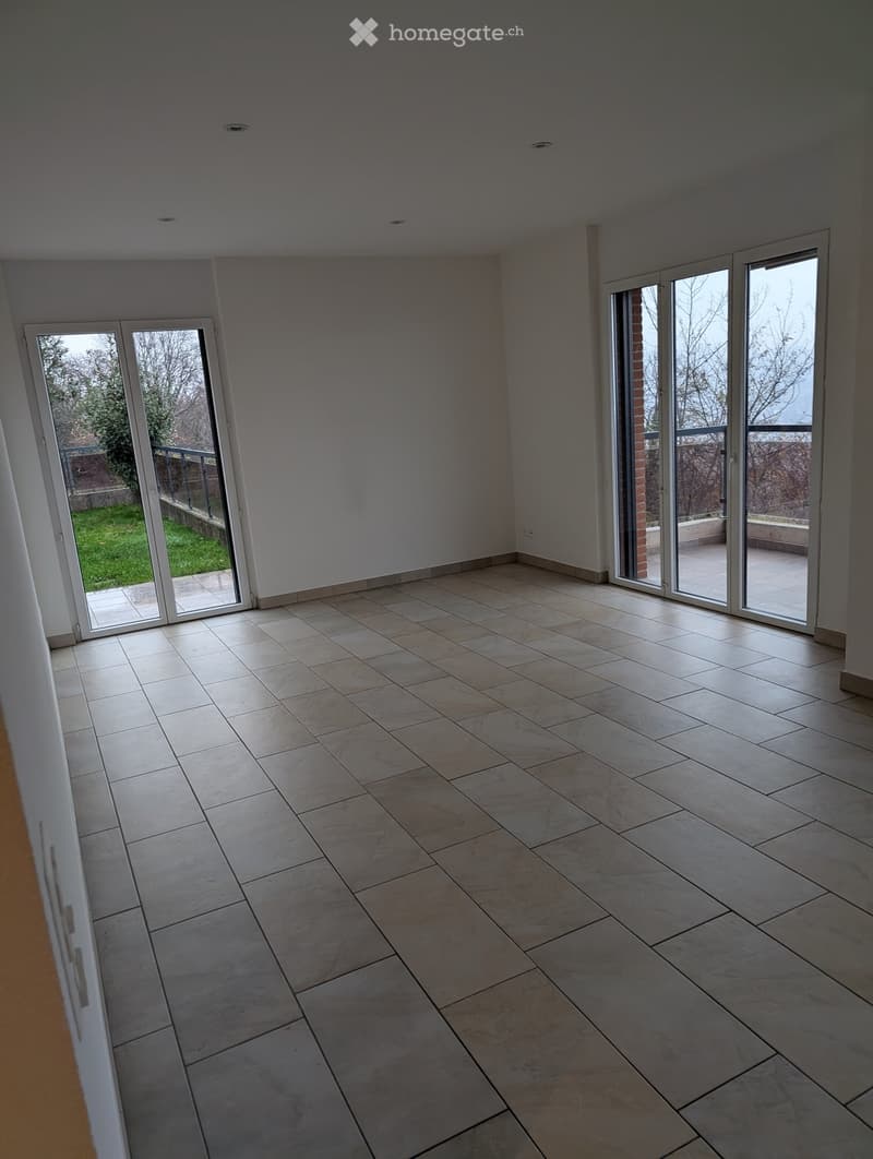 Empty room with large sliding glass doors leading to a patio, tiled floor, and white walls.